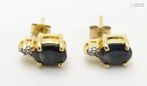 A pair of silver gilt stud earrings set with blue and white stones. Approx. 3/8