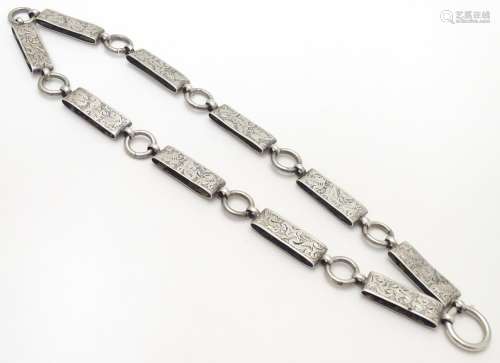 A Victorian white metal book chain necklace with engraved decoration. Approx. 15