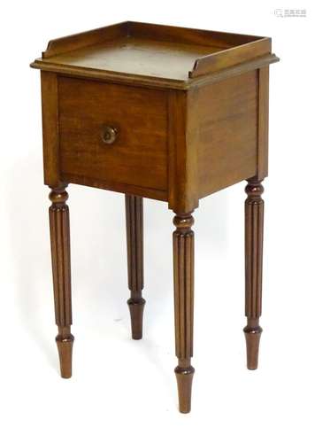 A mid 19thC mahogany pot cupboard with a shaped upstand above a single door with a knob handle,