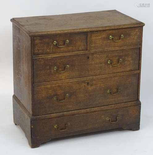 An oak Georgian chest of drawers comprising two short over three long drawers with brass swan neck