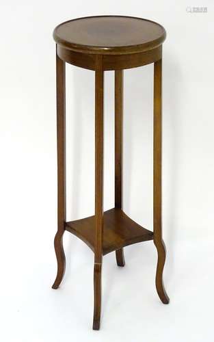 An early 20thC mahogany jardinière stand with a circular moulded top and having decorative satinwood