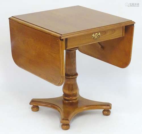 A late 20thC elm table with drop flaps above a single short drawer with brass handles and brass back