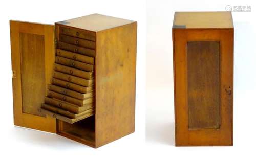 A late 19thC / early 20thC artists cabinet with a panelled door and thirteen oak slides and