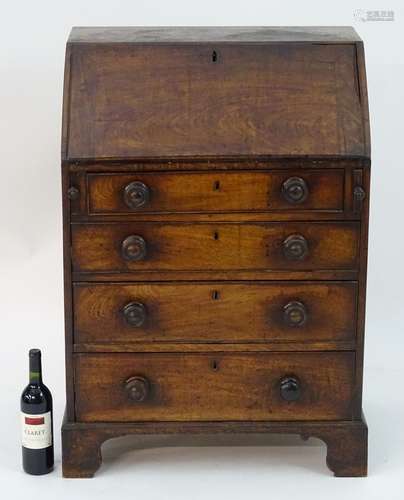 A Georgian mahogany bureau of small proportions, having a fall front containing pigeon holes and