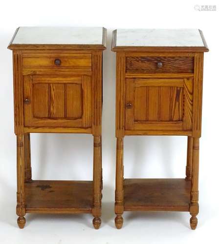 A pair of late 19thC / early 20thC pine bedside cabinets with inset marble tops, each cabinet having