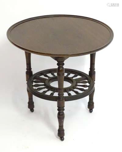 A late 19thC mahogany occasional table with a lazy Susan top and rounded under tier with turned