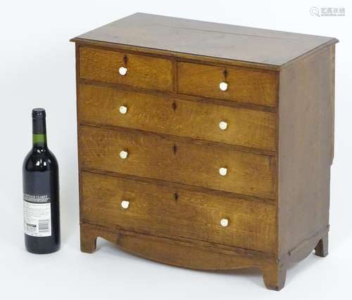 A 19thC oak apprentice chest of drawers, having a moulded top above two short over three long