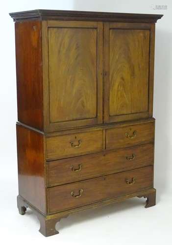 A late 18thC mahogany linen press with a moulded cornice above two panelled doors opening to show