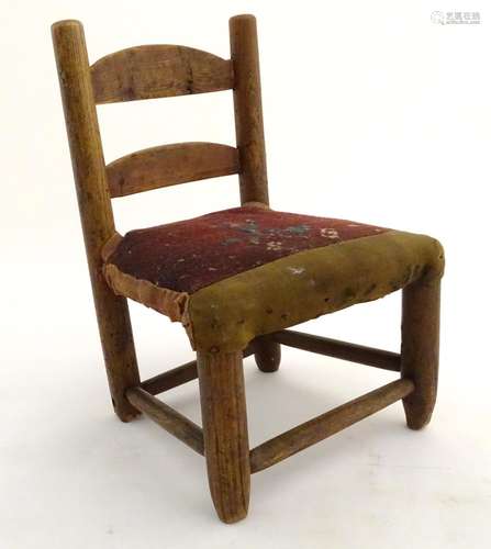 A Victorian doll's chair of elm construction with a tapestry upholstered seat. Approx. 12 1/2