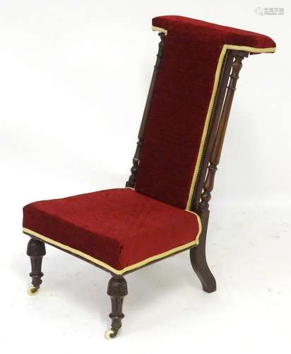 A late 19thC prie dieu with turned supports, burgundy upholstery with a cream trim and standing on