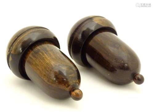 Two 19thC lignum vitae treen containers formed as acorns unscrewing to reveal a lead weight