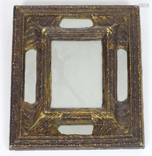 A 20thC mirror with an embossed frame. 11