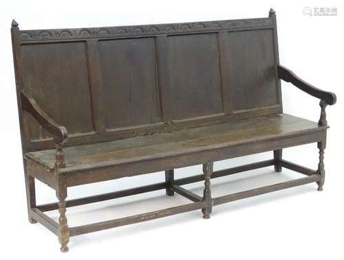 An early / mid 18thC oak settle with nulled carving to the top rail, having pointed terminals to the