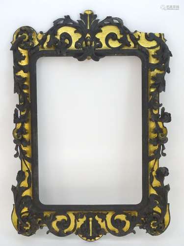 An early 20thC ebonised mirror frame with gilt highlights and foliate carvings. 61? high x 42?