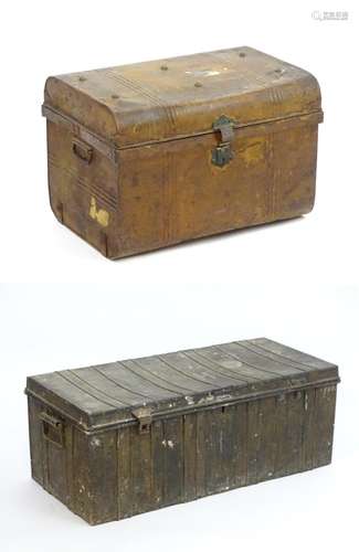 Two late 19thC tin trunks with lifting lids and flanked by carrying handles. The largest measuring