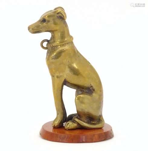 A late 19th / early 20thC brass model of a seated dog on a circular hardstone base. Approx. 2 1/2