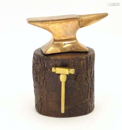 An early 20thC small proportion brass model anvil mounted on a tree stump base with hammer.