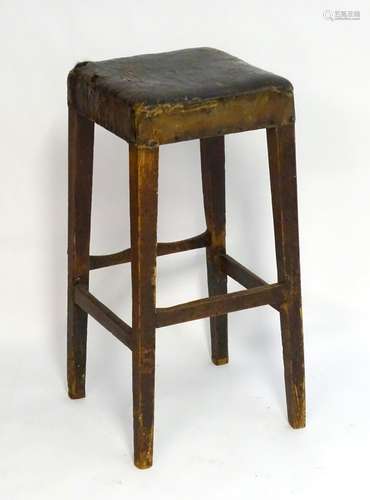 A late 19thC pine stool with a squared top above four tapering legs united by a box stretcher. 16