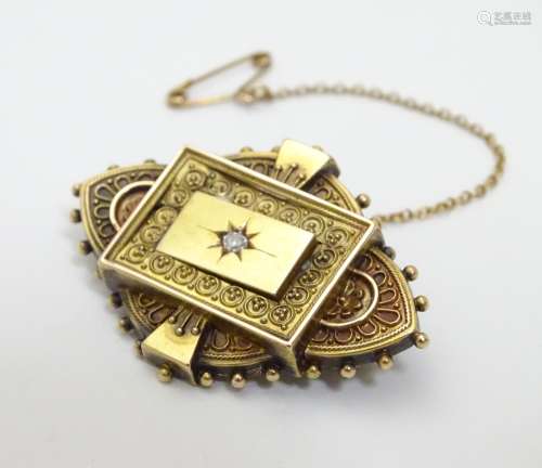 A Victorian 15ct gold brooch set with central diamond. 1 1/2