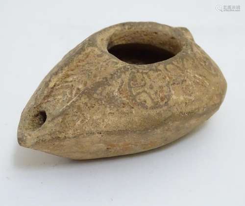 A Roman style terracotta oil lamp with incised decoration. Approx. 1 1/2