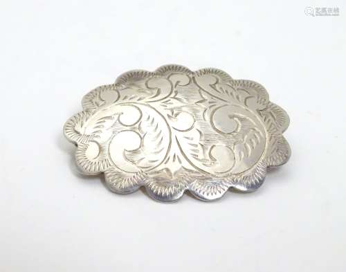 A silver brooch of scalloped oval form with engraved decoration, marked Sterling Thailand. 1 1/4