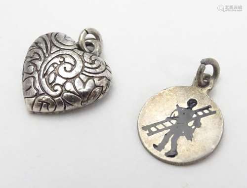 Two pendant charms, one f heart form, the other circular with silhouette decoration. Each approx.
