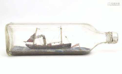 A 20thC ship in a bottle / diorama depicting Kindred Star LT177, a steam trawler boat at sea.