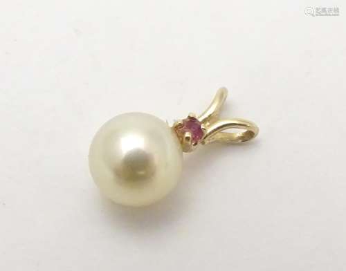 A 9ct gold pendant set with pearl and red spinel. Approx 1 /4
