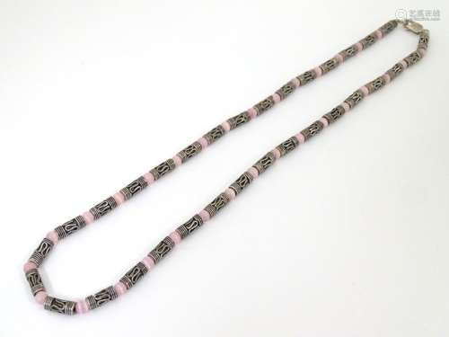 A silver and white metal necklace set with pink cats eye beads. Approx 16'' long Please Note - we do