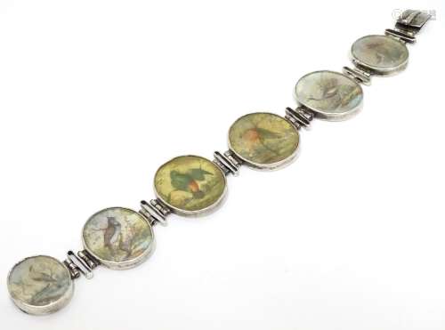 A Victorian white metal bracelet set with 6 locket roundels containing hand painted studies of birds