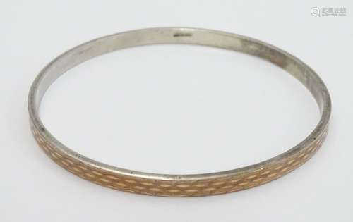 A large silver gilt bracelet / arm bracelet of bangle form with engine turned decoration. Please