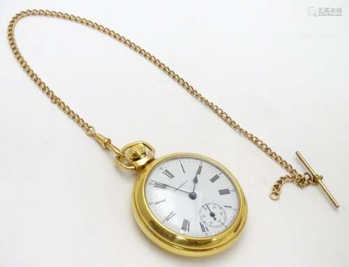 An Ingersoll gold plated open faced pocket watch on gold plated watch chain. White enamel dial