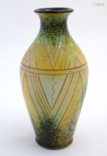 A 20thC studio pottery baluster vase with incised geometric decoration. Impressed G maker's mark
