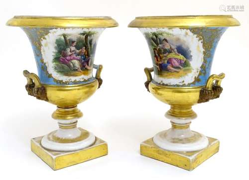 A pair of hand painted twin handled campagna urns, each decorated with a young seated couple on a