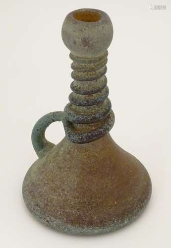 An amber glass jug with loop handle and coiled decoration to neck, with oxidised finish. In the