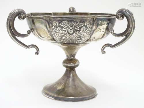 A silver pedestal dish with three handles and embossed decoration. Hallmarked Birmingham 1906