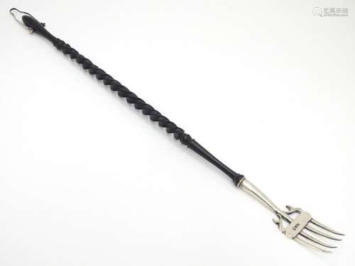 A silver toasting fork with turned ebonised handle. The silver fork section hallmarked Chester