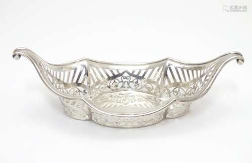 A Silver boat-shaped dish with scroll ends and pierced decoration. Bears a small yacht style mark