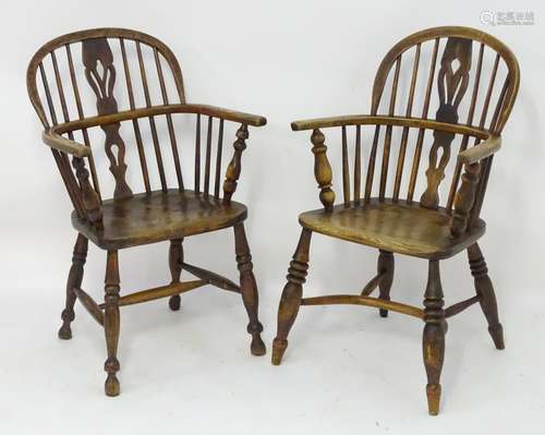 Two early 19thC ash and elm double bow back Windsor chairs with pierced back splats above shaped