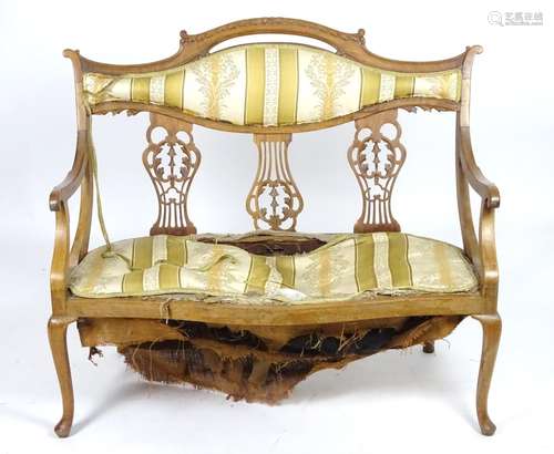 An early 20thC sofa with a shaped carved cresting rail above three central pierced back splats and