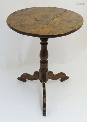 A 19thC tripod table with a rounded top above a turned pedestal base and three shaped legs. 21