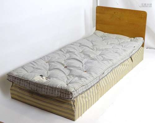 An early 20thC Heels bed, having an oak headboard above an original Heals sprung mattress and