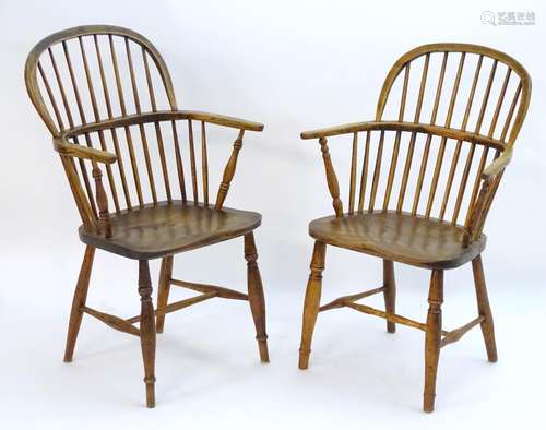 Two early 19thC elm and ash double bow back Windsor chairs, with turned spindle supports above