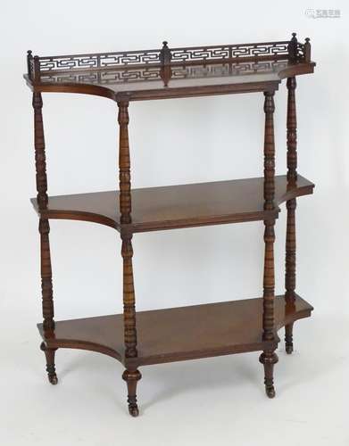 A late 19thC mahogany etagere with a pierced upstand above three shaped tiers with four ring