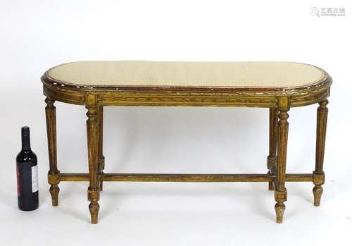 A late 19thC / early 20thC giltwood stool with an oval upholstered top above a moulded frame and six