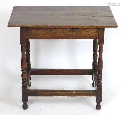 An early 20thC oak side table with a proud top above a single short drawer, the table raised on