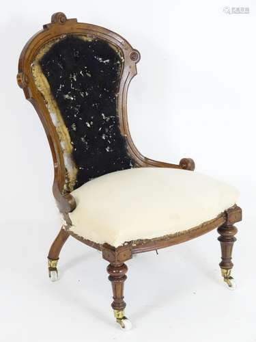 A Victorian slipper chair for re upholstery. Having a carved frame with roundel decoration and