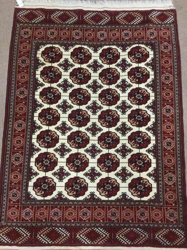 PERSIAN FRINGED RUG, decorated in shades of red with blue on a cream ground, 175cm x 120cm