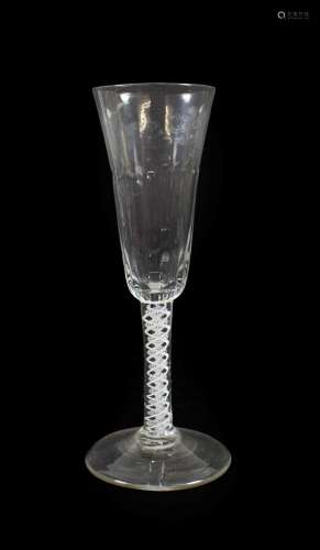 An Ale Flute, circa 1750, the semi-fluted rounded funnel bowl on an opaque twist stem and circular