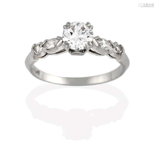 A Diamond Solitaire Ring, the round brilliant cut diamond in a white claw setting, to a marquise and